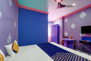 ein blaues Zimmer mit einem Bett und einer blauen Wand in der Unterkunft OYO Hotel Divyanka Lodge in Guwahati