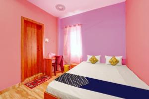 ein Schlafzimmer mit einem großen Bett mit lila Wänden in der Unterkunft OYO Hotel Divyanka Lodge in Guwahati