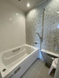 uma casa de banho branca com uma banheira e um chuveiro em THE LAND HOTEL - Vacation STAY 89073v em Arao