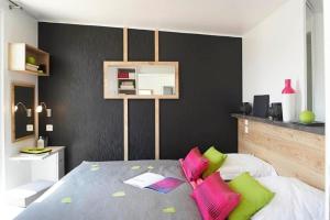 a bedroom with a bed with pink and green pillows at Ferienhaus in Wackersdorf mit Whirlpool, Terrasse und Grill - b48657 in Wackersdorf