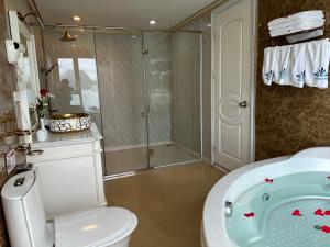 ein Badezimmer mit einer Dusche, einem WC und einer Badewanne in der Unterkunft Halong AQUAR CRUISE in Hạ Long