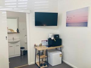 a room with a desk and a sink in a room at The Platypus Accommodation & Cafe in Cudal