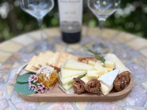 um prato de queijo e bolachas numa mesa com copos de vinho em Bel Abri Napa Valley Inn em Napa