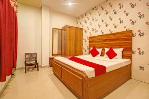 ein Schlafzimmer mit einem großen Bett mit roten Kissen in der Unterkunft Super OYO Hotel NR Residency in Banūr