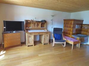 a room with a desk and a tv and a chair at Steffelhüs 8-Bettwohnung - b48637 in Hasliberg