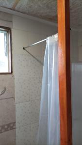 y baño con ducha con cortina blanca. en El salto, en Puerto Aysén