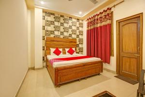 ein Schlafzimmer mit einem Bett und einem roten Vorhang in der Unterkunft Super OYO Hotel NR Residency in Banūr