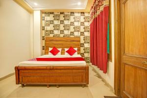 a bedroom with a bed with red pillows on it at Super OYO Hotel NR Residency in Banūr