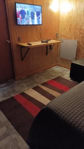 Zimmer mit einem Schreibtisch und einem TV an der Wand in der Unterkunft El salto in Puerto Aisén