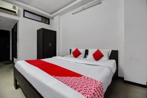 a bedroom with a large bed with red pillows at OYO Hotel Real Residency in Jodhpur
