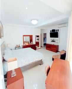 a bedroom with a bed and a flat screen tv at D'eluxe Hotel Talara- ubicado a 5 minutos del aeropuerto y a 8 minutos del centro civico in Talara