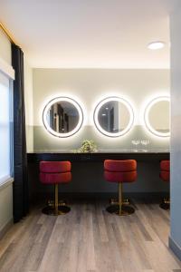 a salon with two mirrors and two red stools at The Darwin Hotel in Atlanta