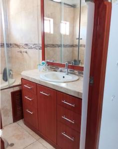 een badkamer met een wastafel en een spiegel bij D'eluxe Hotel Talara ubicado a 5 minutos del aeropuerto y a 8 minutos del Centro Civico in Talara
