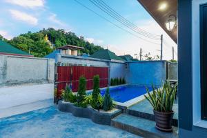 a house with a red and blue fence and plants at N&D Poolvilla (1, 2, 3, 4) in Ao Nang Beach