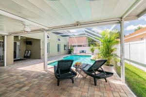 a patio with two chairs and a swimming pool at (HGR) Poolside Paradise: Vacation retreat. (Heated Pool) in Tampa