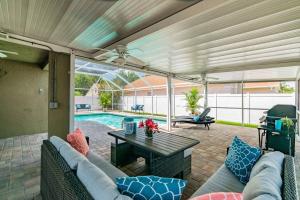 a patio with a couch and a table and a pool at (HGR) Poolside Paradise: Vacation retreat. (Heated Pool) in Tampa