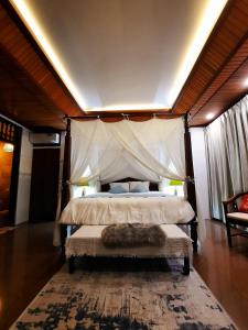 a bedroom with a bed with a canopy at Villia magnolia sanur bali 巴厘島玉蘭別墅 in Denpasar