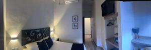 - une chambre avec un lit et une télévision murale dans l'établissement Centrico House, à Taxco