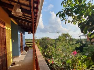 een veranda van een huis met uitzicht op een tuin bij Quintal da Espera - Praia de Itacimirim in Camaçari