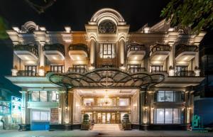 a large building with a lit up facade at night at Victoria Suites Westlake Hanoi in Hanoi