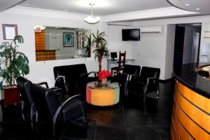 a meeting room with black chairs and a table at La Défense Apart Hotel in Montes Claros