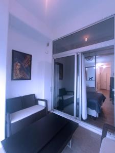 a living room with a couch and a large window at APARTAMENTO CON TERRAZA CERCA DEL AEROPUERTO in Guatemala