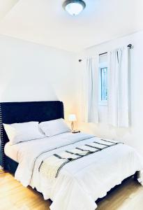 uma cama branca com uma cabeceira preta num quarto em LaVida Exclusive Guest House (Rm #3) em London