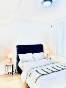 um quarto branco com uma cama grande e 2 candeeiros em LaVida Exclusive Guest House (Rm #3) em London