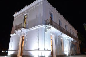 un edificio blanco con luces encendidas por la noche en Hotel El Recreo en General Roca