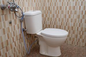 een badkamer met een wit toilet in een stal bij Family Guest House Moni in Kelimutu