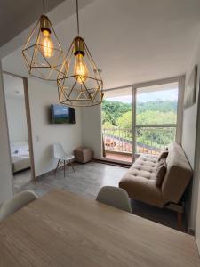 a living room with a table and a large window at Apartamento en entorno natural in Villeta