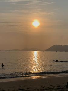 a person swimming in the ocean at sunset at Praia e sossego in Angra dos Reis