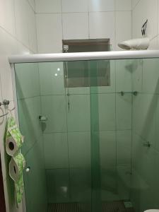a glass shower in a bathroom with a roll of toilet paper at Praia e sossego in Angra dos Reis