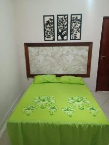 a green bed with two pillows on top of it at Praia e sossego in Angra dos Reis