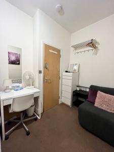 1 dormitorio con escritorio, 1 cama, escritorio y ordenador en Metropolitan Coziness Private Bedrooms in Euston Station 161, en Londres