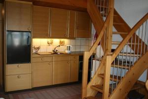 a kitchen with wooden cabinets and a staircase at Ferienwohnung mit Herz - b48778 in Horboden