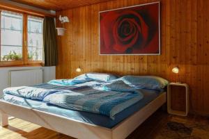 a bedroom with a bed with a painting on the wall at Chalet Burgstein, Wohnung Silberdistel - b48794 in Grindelwald