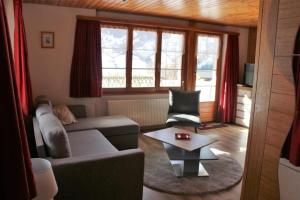 a living room with a couch and a table at Chalet Burgstein, Wohnung Silberdistel - b48794 in Grindelwald