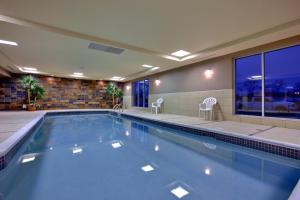 una gran piscina con 2 sillas en un edificio en Holiday Inn Express Hotel & Suites Chatham South, an IHG Hotel, en Chatham