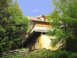 een huis met een balkon aan de zijkant van een heuvel bij Almhüttenurlaub in Kärnten mit herrlicher Aussicht auf die Berge - b48725 in Klippitztorl
