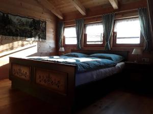 uma cama grande num quarto com janelas em Almhüttenurlaub in Kärnten mit herrlicher Aussicht auf die Berge - b48725 em Klippitztorl