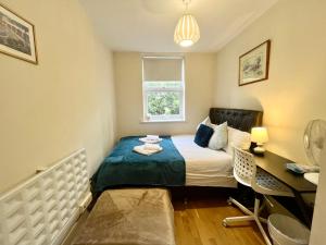 Habitación pequeña con cama y escritorio. en Metropolitan Coziness Private Bedrooms in Euston Station 161, en Londres