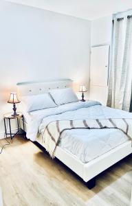 ein weißes Bett in einem weißen Schlafzimmer mit zwei Lampen in der Unterkunft LaVida Exclusive Guest House(Rm#4) in London