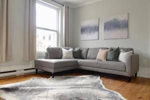 a living room with a gray couch and a window at Historic Downtown Apt #2 in Halifax