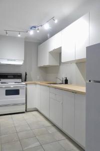 a white kitchen with white cabinets and a stove at Historic Downtown Apt #2 in Halifax