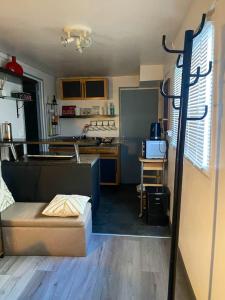 uma pequena cozinha com um sofá num quarto em Appartement d'une chambre avec jardin amenage et wifi a Corbeil Essonnes em Corbeil-Essonnes
