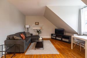 a living room with a couch and a tv at Sunny Loft #4, Historic Home in Halifax