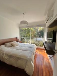 a bedroom with a bed and a desk and a large window at Departamento Premium en Belgrano con Pileta in Buenos Aires