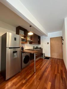 a kitchen with a stainless steel refrigerator and wooden floors at Departamento Premium en Belgrano con Pileta in Buenos Aires