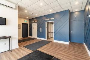 Cette grande chambre est dotée d'un mur bleu et d'une télévision. dans l'établissement Bright & Spacious 2-BDRM Apt #6A, Patio, à Halifax